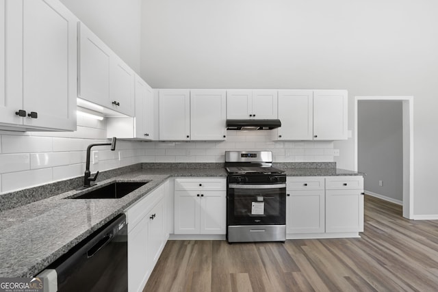 1404 Meadowind Ct SW, Conyers, GA 30094 - kitchen with stainless steel gas range oven, black dishwasher, a sink, under cabinet range hood, and white cabinets