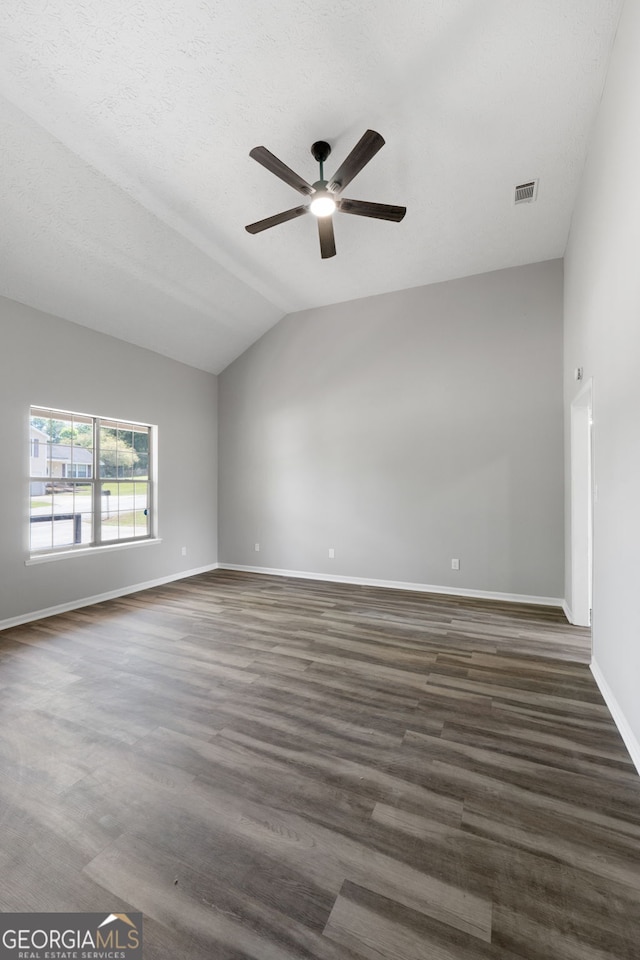 1404 Meadowind Ct SW, Conyers, GA 30094 - empty room with ceiling fan, vaulted ceiling, baseboards, and dark wood-type flooring