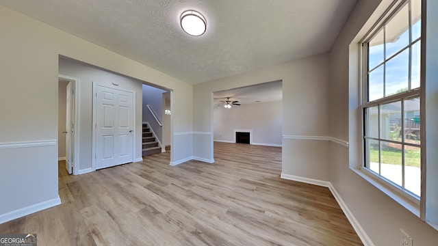10961 Big Sky Dr, Hampton, GA 30228 - spare room featuring a textured ceiling, stairs, light wood-style floors, baseboards, and ceiling fan