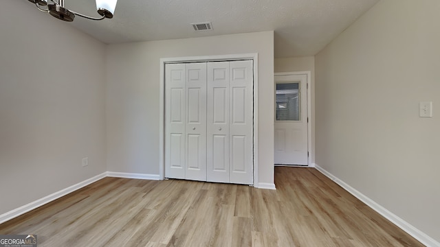 10961 Big Sky Dr, Hampton, GA 30228 - unfurnished bedroom featuring light wood-style flooring, a closet, and a chandelier