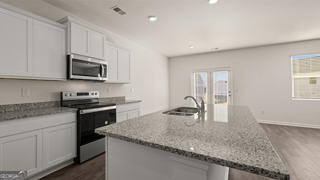 75 Poplar Blvd, Newnan, GA 30265 - kitchen with appliances with stainless steel finishes, a sink, dark wood-style floors, a center island with sink, and light stone counters