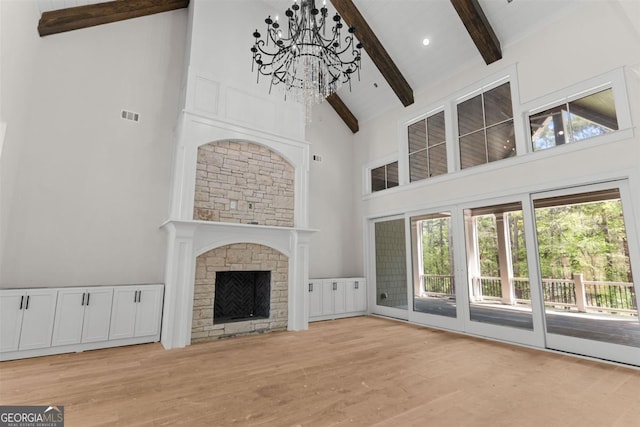 1111 Swift Crk, Greensboro, GA 30642 - unfurnished living room with high vaulted ceiling, beamed ceiling, wood finished floors, a chandelier, and a fireplace