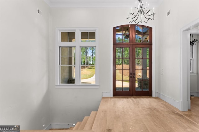 1111 Swift Crk, Greensboro, GA 30642 - foyer entrance with french doors, a chandelier, and wood finished floors