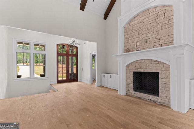 1111 Swift Crk, Greensboro, GA 30642 - unfurnished living room featuring high vaulted ceiling, beam ceiling, wood finished floors, a chandelier, and a stone fireplace