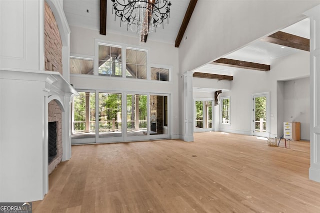 1111 Swift Crk, Greensboro, GA 30642 - unfurnished living room featuring high vaulted ceiling, beamed ceiling, wood finished floors, a fireplace, and a chandelier