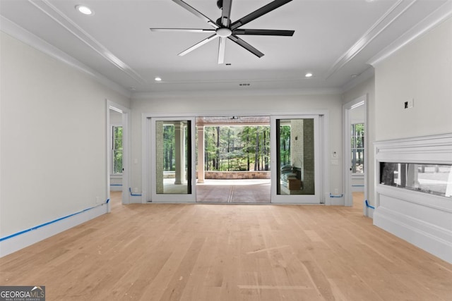 1111 Swift Crk, Greensboro, GA 30642 - unfurnished living room with light wood-type flooring, plenty of natural light, crown molding, recessed lighting, and a tray ceiling