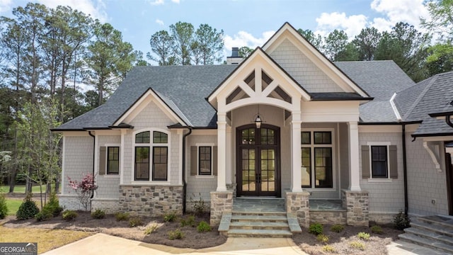 1111 Swift Crk, Greensboro, GA 30642 - view of front of home featuring french doors, roof with shingles, a chimney, and stone siding
