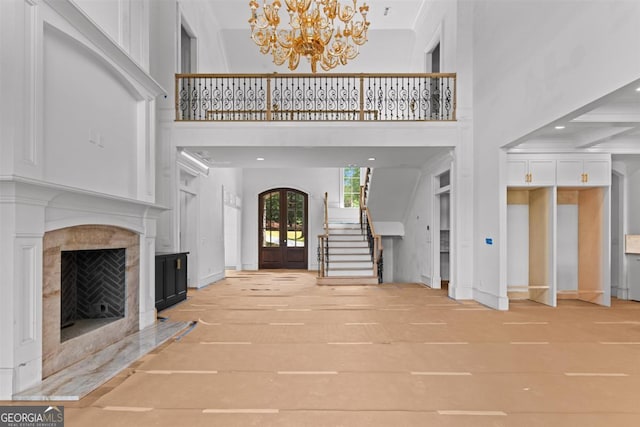 5010 Browns Ford Rd, Greensboro, GA 30642 - unfurnished living room with a high ceiling, french doors, a chandelier, stairway, and a premium fireplace