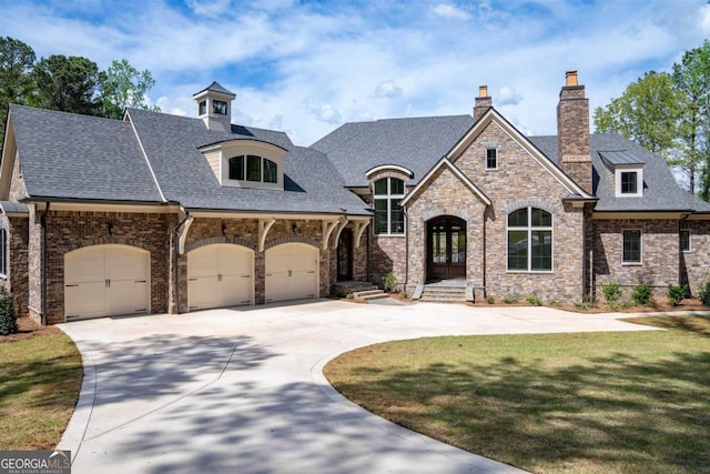 5010 Browns Ford Rd, Greensboro, GA 30642 - french country inspired facade featuring concrete driveway, a garage, french doors, roof with shingles, and a chimney
