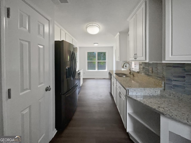 4335 Northwind Dr, Ellenwood, GA 30294 - kitchen with black fridge, a sink, dark wood finished floors, tasteful backsplash, and white cabinetry