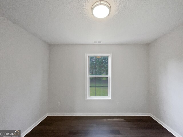 4335 Northwind Dr, Ellenwood, GA 30294 - empty room with dark wood-type flooring, baseboards, and a textured ceiling