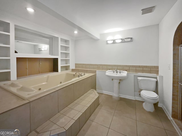 4335 Northwind Dr, Ellenwood, GA 30294 - bathroom featuring toilet, tile patterned floors, a tub with jets, built in shelves, and tile walls