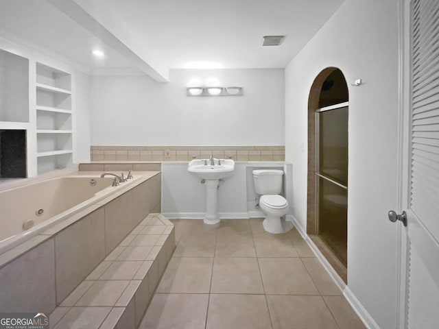 4335 Northwind Dr, Ellenwood, GA 30294 - bathroom featuring toilet, tile patterned flooring, a tub with jets, a stall shower, and a wainscoted wall