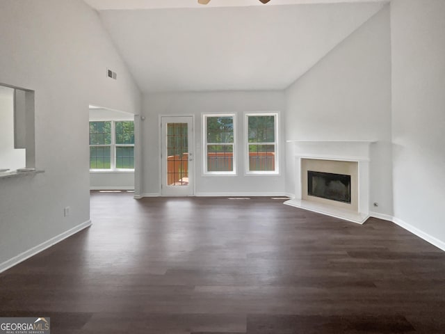 4335 Northwind Dr, Ellenwood, GA 30294 - unfurnished living room featuring ceiling fan, wood finished floors, baseboards, a glass covered fireplace, and high vaulted ceiling