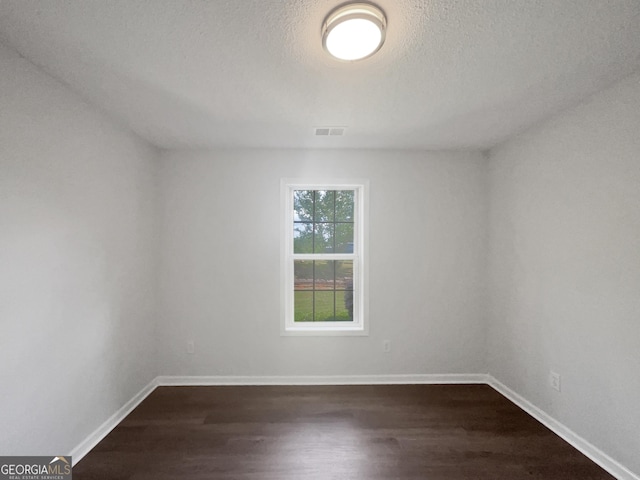 4335 Northwind Dr, Ellenwood, GA 30294 - spare room featuring dark wood-type flooring, baseboards, and a textured ceiling