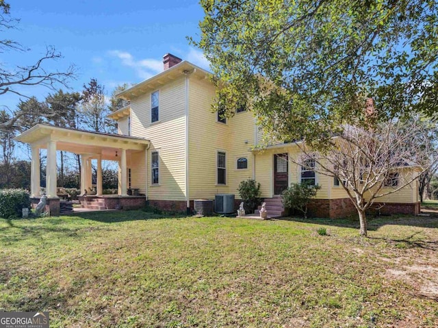 3021 Teamon Rd, Griffin, GA 30223 - back of house with central AC unit, a lawn, and a chimney
