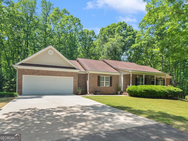 single story home with concrete driveway, brick siding, a front lawn, and an attached garage