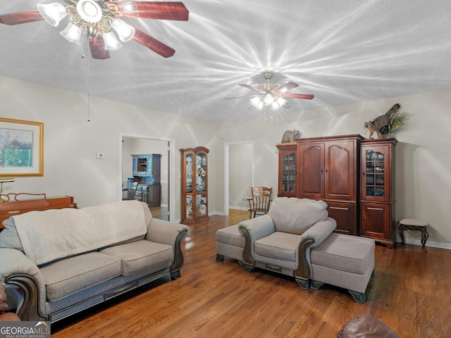 living room with ceiling fan, wood finished floors, and baseboards