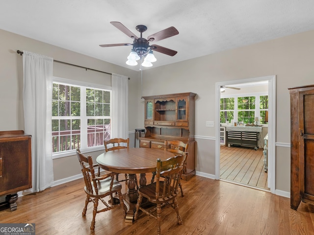 dining area with ceiling fan, light wood-style flooring, and baseboards
