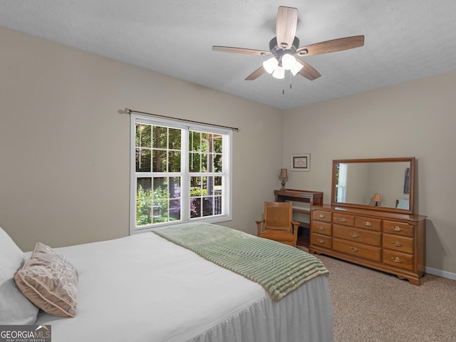 carpeted bedroom with ceiling fan and baseboards