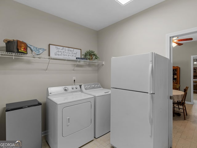 washroom with washer and clothes dryer and baseboards