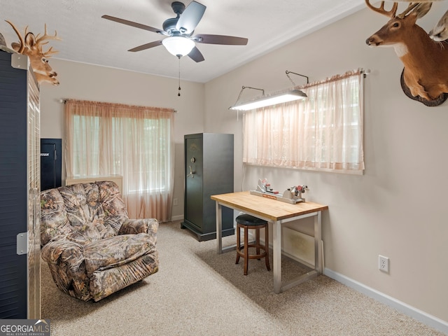 carpeted office featuring a ceiling fan and baseboards