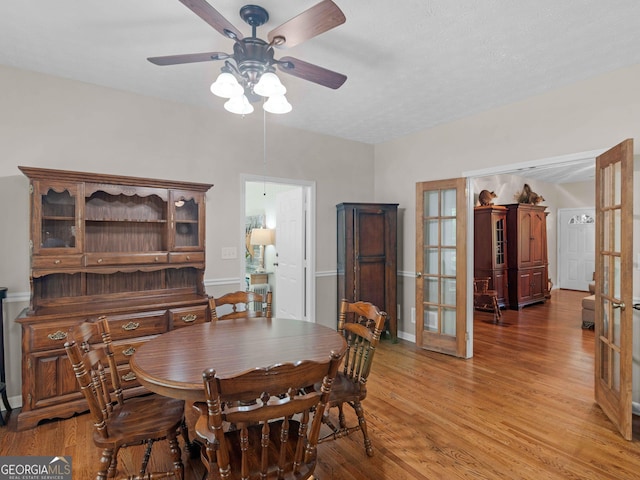 dining room featuring a ceiling fan, light wood-style flooring, french doors, and baseboards
