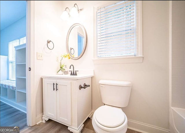 21 Whitegrass Way, Grayson, GA 30017 - full bathroom featuring wood finished floors, toilet, vanity, a tub, and baseboards