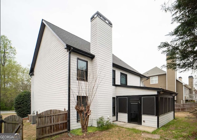 21 Whitegrass Way, Grayson, GA 30017 - rear view of house featuring a chimney, a sunroom, fence, and central air condition unit