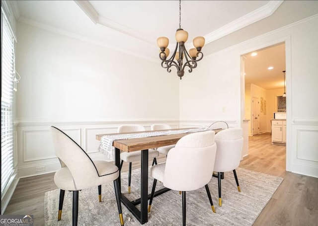 21 Whitegrass Way, Grayson, GA 30017 - dining space featuring light wood-style flooring, healthy amount of natural light, a chandelier, crown molding, and a decorative wall