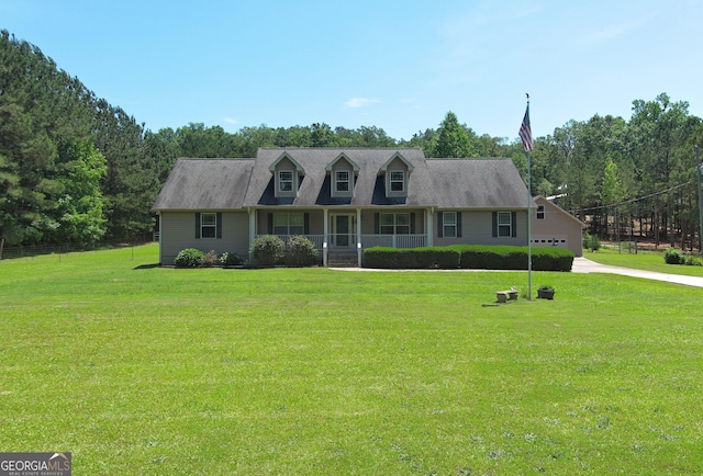 view of front of home with a porch, a front yard, and driveway