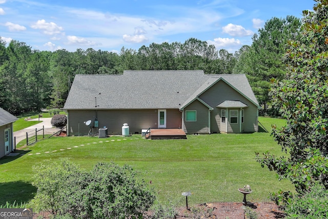 rear view of house with a deck and roof with shingles