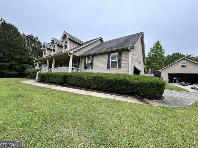 view of home's exterior with covered porch, a lawn, and an outbuilding