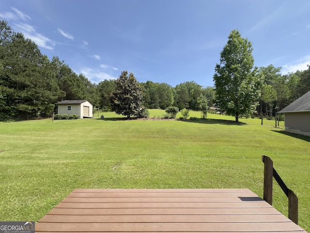 view of grassy yard with an outdoor structure, a shed, and view of scattered trees