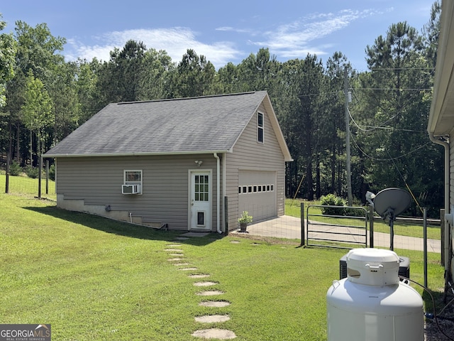 view of side of home with a shingled roof, a garage, and an outdoor structure