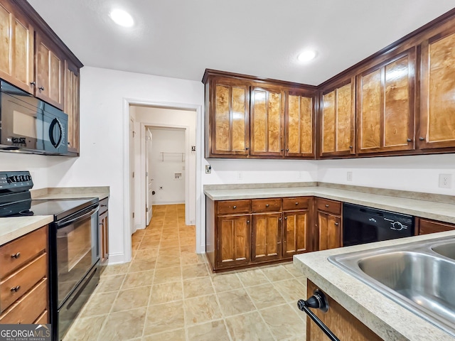 kitchen with black appliances, light countertops, a sink, recessed lighting, and light tile patterned floors