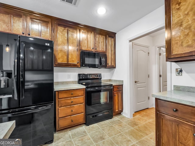 kitchen with black appliances, light countertops, and brown cabinetry