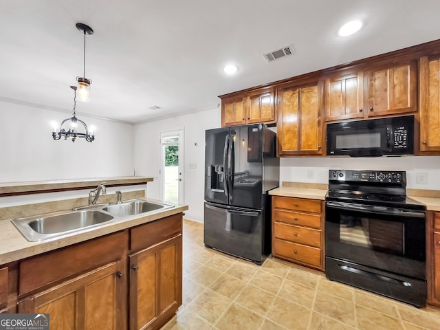 kitchen with black appliances, a sink, hanging light fixtures, brown cabinets, and light countertops