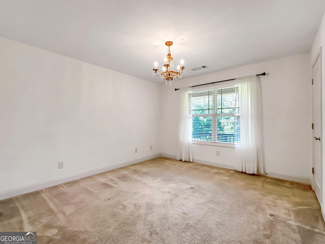 spare room with a chandelier, baseboards, and light carpet