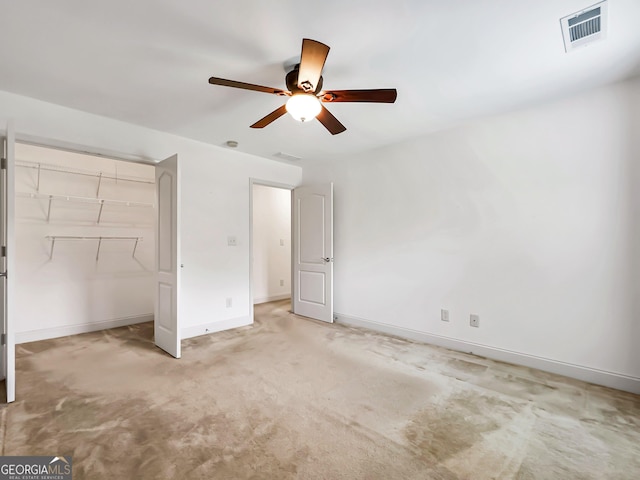 unfurnished bedroom with light colored carpet, a closet, baseboards, and ceiling fan
