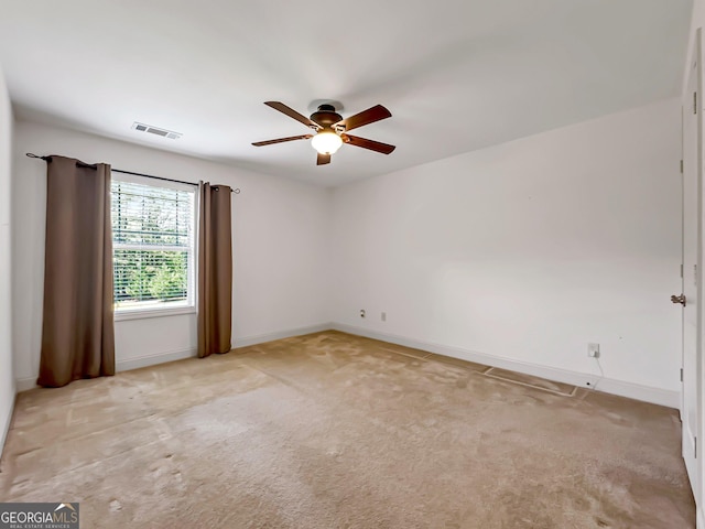 unfurnished room with a ceiling fan, light carpet, and baseboards