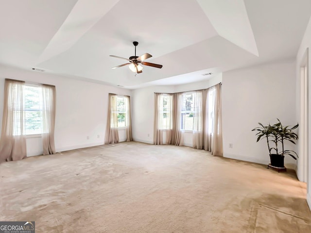 empty room with ceiling fan, light colored carpet, and baseboards