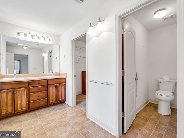 full bathroom with double vanity, toilet, baseboards, and tile patterned floors