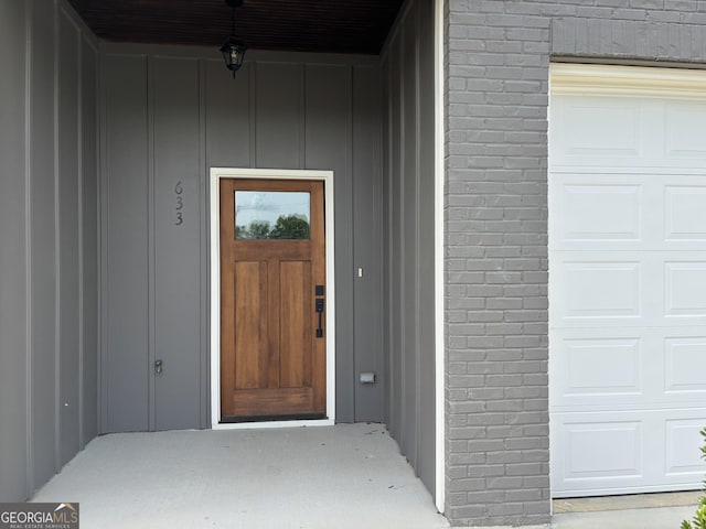 633 E 3rd St, Rome, GA 30161 - doorway to property with board and batten siding and a garage