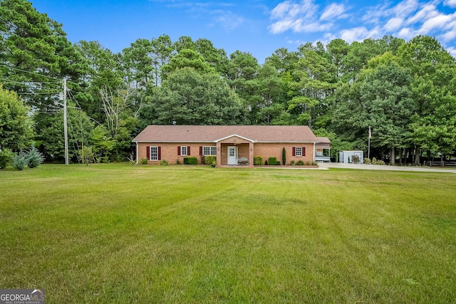 ranch-style home with a front lawn, brick siding, and concrete driveway