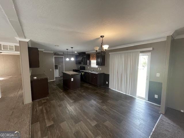 507 Jackson St, Montezuma, GA 31063 - kitchen featuring a chandelier, dark wood finished floors, a center island, healthy amount of natural light, and ornamental molding
