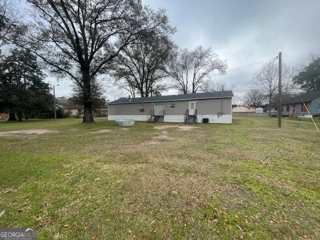 507 Jackson St, Montezuma, GA 31063 - back of house featuring a lawn