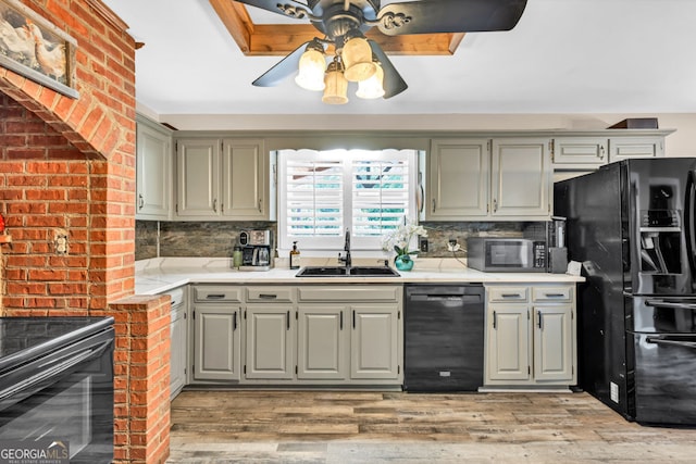 kitchen with black appliances, a sink, a ceiling fan, and backsplash