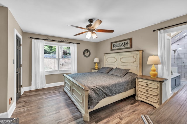 bedroom featuring baseboards, wood finished floors, ceiling fan, and ensuite bathroom