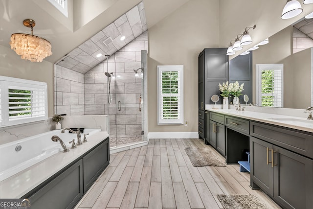 full bath with high vaulted ceiling, a stall shower, a bath, wood finished floors, and plenty of natural light